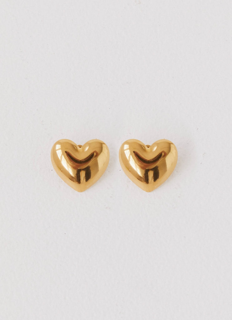 Womens Alexa Heart Earrings in the colour Gold in front of a light grey background