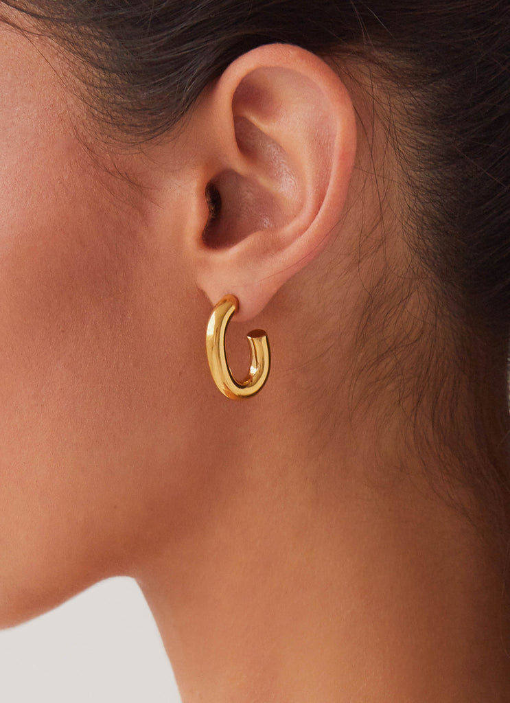 Womens Stardust Hoop Earrings in the colour Gold in front of a light grey background