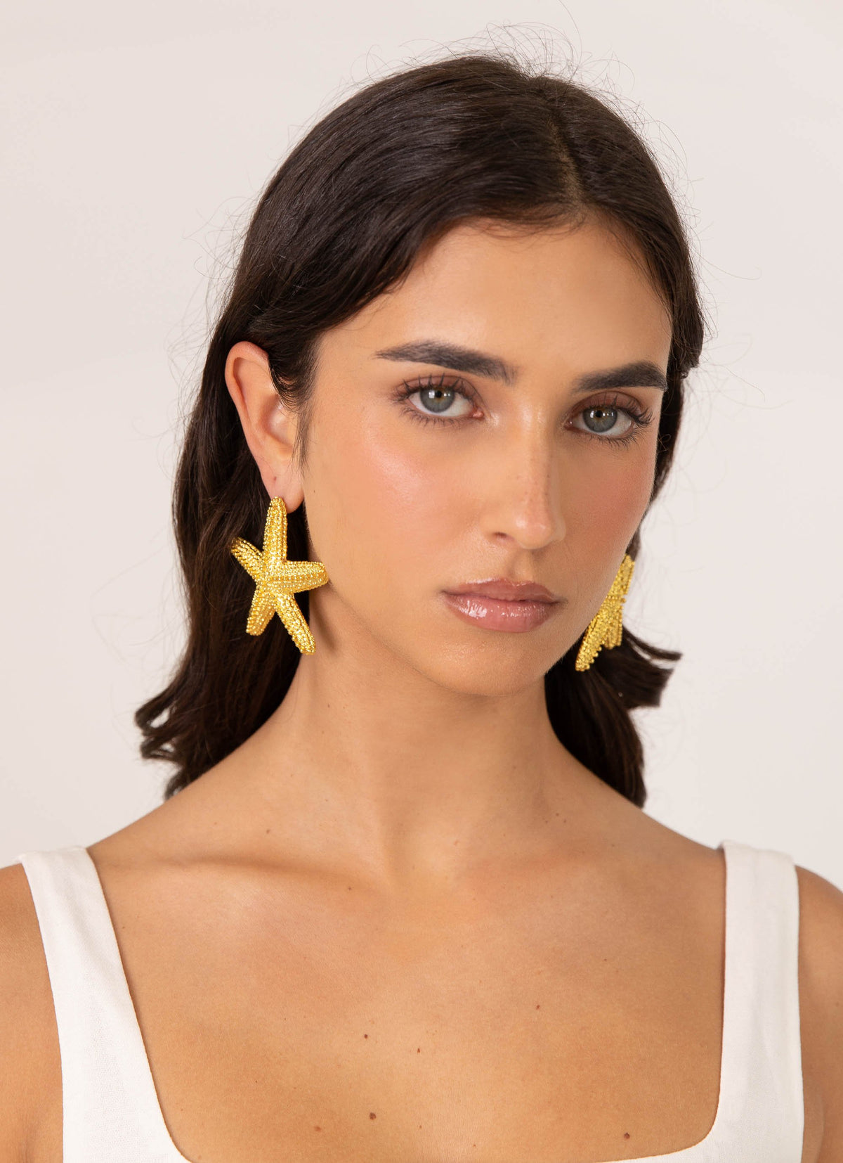 Womens Geneve Starfish Earring in the colour Gold in front of a light grey background